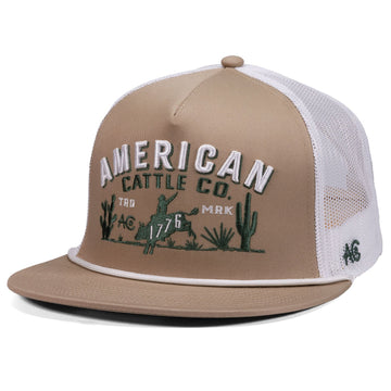 The American Cattle Co 8-Second Hat in tan/white features a mesh back, "AMERICAN CATTLE CO." embroidery with cacti, a cowboy on horseback, and "1776," blending classic Western style and breathable comfort.