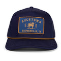 The Rural Cloth Stockman Hat is a navy blue trucker with a yellow 