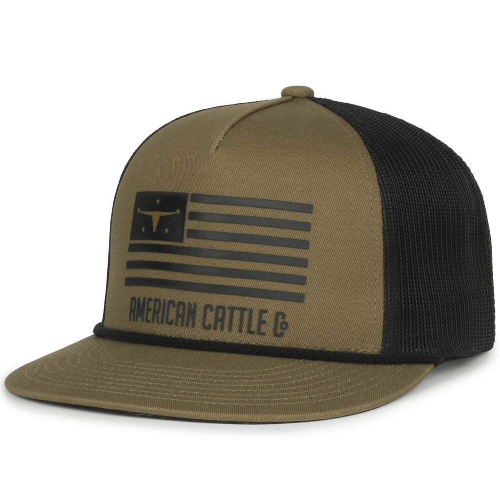 The ACC Flag Hat by Rural Cloth is a khaki-colored baseball cap with a black mesh snapback. The front of the cap features a black graphic of a flag with a longhorn symbol in the top left corner and the text 