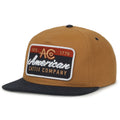 The ACO Hat by Rural Cloth is a brown and black structured snapback cap with a flat brim, featuring a large front patch embroidered with 