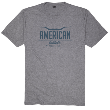 The American Cattle Co Tee features a heather gray design with "AMERICAN Cattle Co.", a longhorn graphic above, and "WE RANCH. YOU EAT." below—ideal for those who embrace the ranching and farming way of life.
