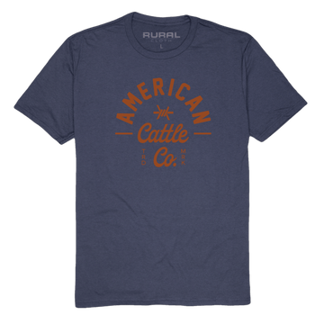 The Barb Tee by American Cattle Co is a navy premium cotton blend t-shirt with "American Cattle Co." in bold orange on the front and a subtle "Rural" print inside the neck—perfect for ranchers.