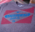 A heathered purple Billboard Tee by Rural Cloth with a red and blue 