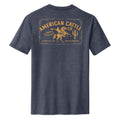 The Bucking Horse Tee by Rural Cloth is shown from the back in heathered navy, featuring a yellow graphic of a cowboy riding a bull with “American Cattle Co.” and vintage rodeo-inspired text styled like an old label.
