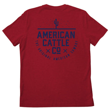 The Cactus Tee by Rural Cloth is a red shirt featuring a bold blue cactus graphic and the phrases "AMERICAN CATTLE CO" and "THE ORIGINAL AMERICAN COWBOY," celebrating classic cattle ranching style.