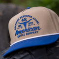 A tan and blue Certified Ranchers Association Hat by Rural Cloth, featuring 
