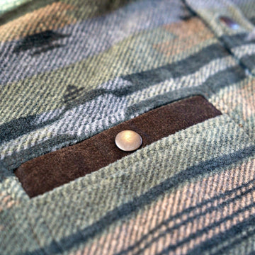 Suede-trimmed chest pocket with snap on the Desperado Polar Fleece in Olive, showing the geometric pattern.