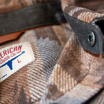 Collar of the Desperado Polar Fleece in Brown with suede collar stand, snap tab and American Cattle Co neck label.