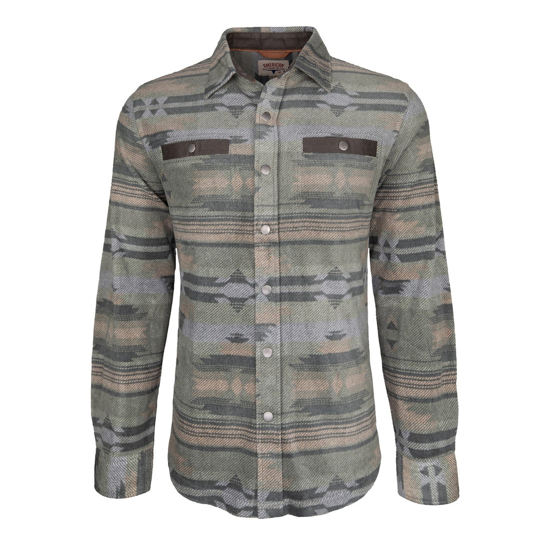 The American Cattle Co Desperado Polar Fleece is a long-sleeve button-up shirt jacket in olive, featuring a subtle geometric pattern in gray, green, and beige shades. It includes two chest pockets with buttoned flaps and a collar. The textured polar fleece fabric offers extra warmth, making it an ideal choice for casual wear.