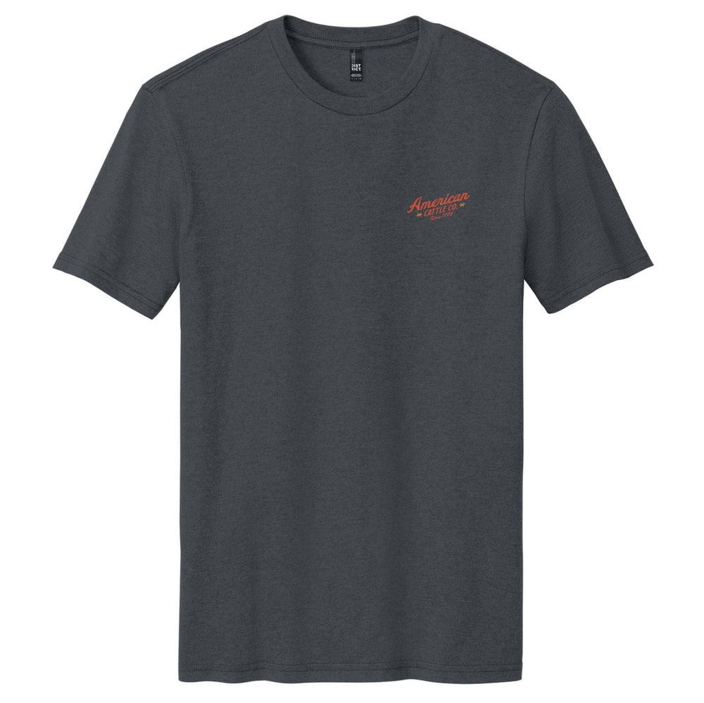 The Frontier Tee by American Cattle Co is a plain dark gray vintage western t-shirt with small red "American Wheels" text on the left chest, a crew neckline, and no other visible designs.