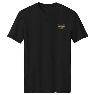 The Heritage Tee by American Cattle Co is a black short-sleeve shirt with a vintage "American Motorcycles" logo on the left chest, shown on a plain white background.
