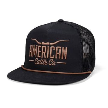 The Longhorn Hat by Rural Cloth is a black and gold 5-panel mesh snapback with a flat brim, featuring "AMERICAN Cattle Co." and a steer horn embroidered on the front—ideal for showcasing ranching style.