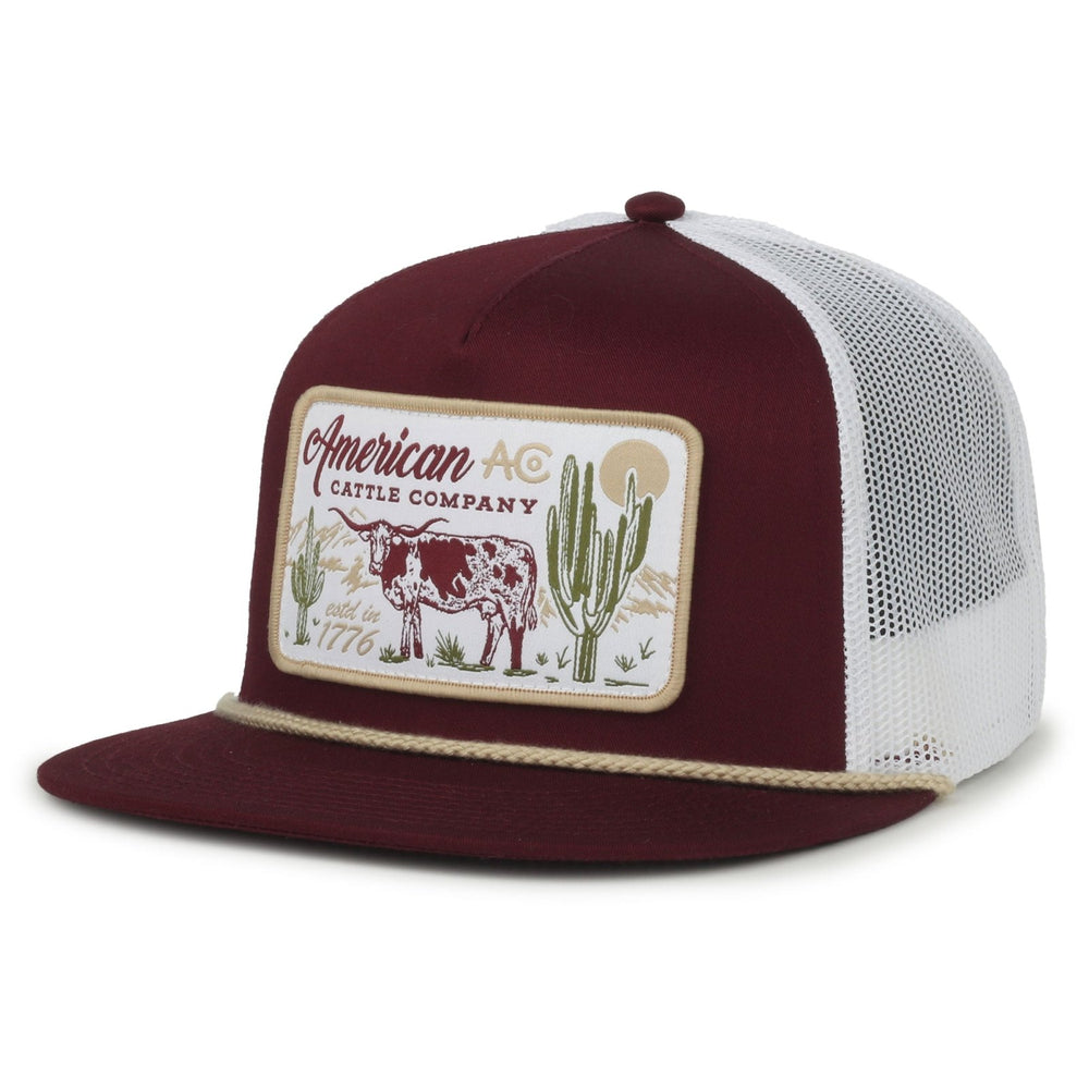 The On the Range Hat by American Cattle Co is a maroon and white snapback with mesh back, flat bill, decorative rope, and a patch displaying "American Cattle Company," a cow, cacti, mountains, and "est. 1776.