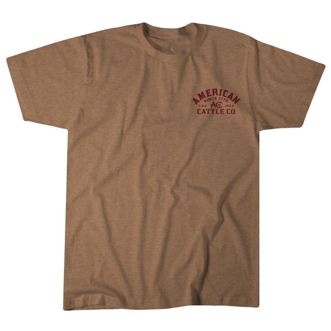 The American Cattle Co On the Range Tee is a plain brown poly-cotton shirt with small maroon "American Cattle Co. Since 1794" text on the left chest in a simple font, displayed flat against a white background.