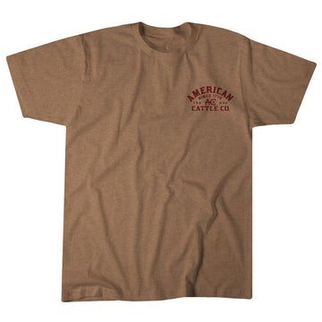 The American Cattle Co On the Range Tee is a plain brown poly-cotton shirt with small maroon "American Cattle Co. Since 1794" text on the left chest in a simple font, displayed flat against a white background.