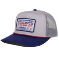 The Patriot Hat by Rural Cloth features gray and navy mesh, a “Buck Town Stephenville, TX” patch, red stars, and a red rope detail—ideal for Americana style fans.