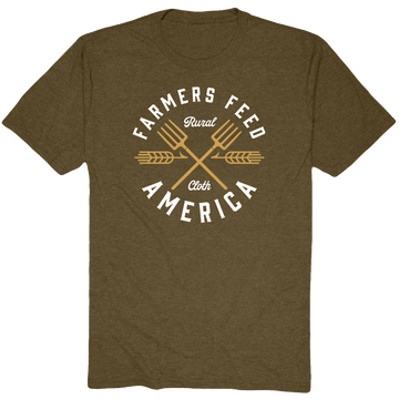 Support American agriculture in style with the olive green Pitchfork Tee by Rural Cloth, featuring white "Farmers Feed America" text, gold brand lettering, crossed pitchforks, and wheat stalks for a timeless look.