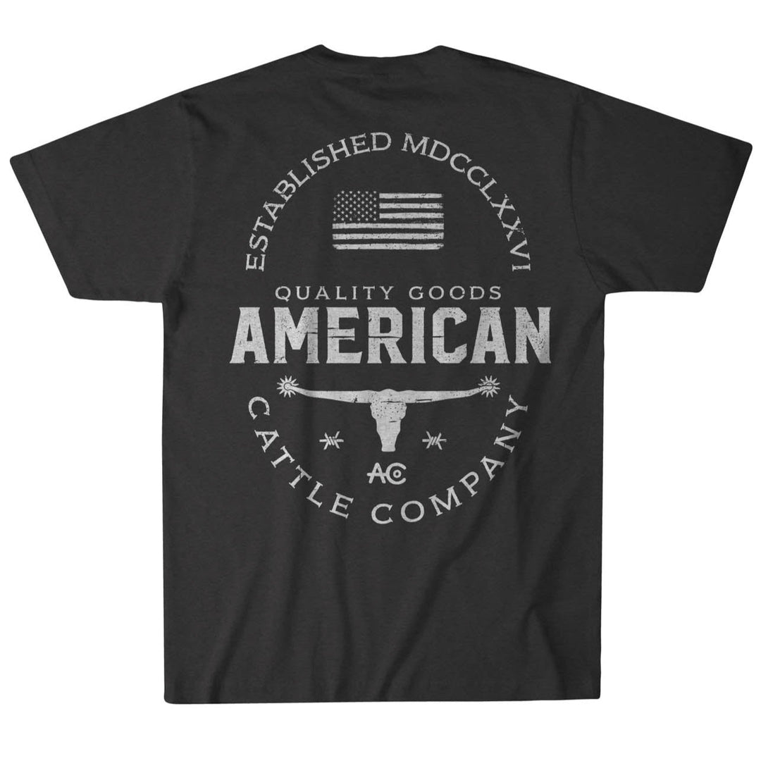 The American Cattle Co Quality Goods Tee is a black, USA-made t-shirt with premium weight fabric and a bold back graphic featuring the American flag, steer skull, "Established MDCCLXXVI," "AO," and "Cattle Company" in white lettering.