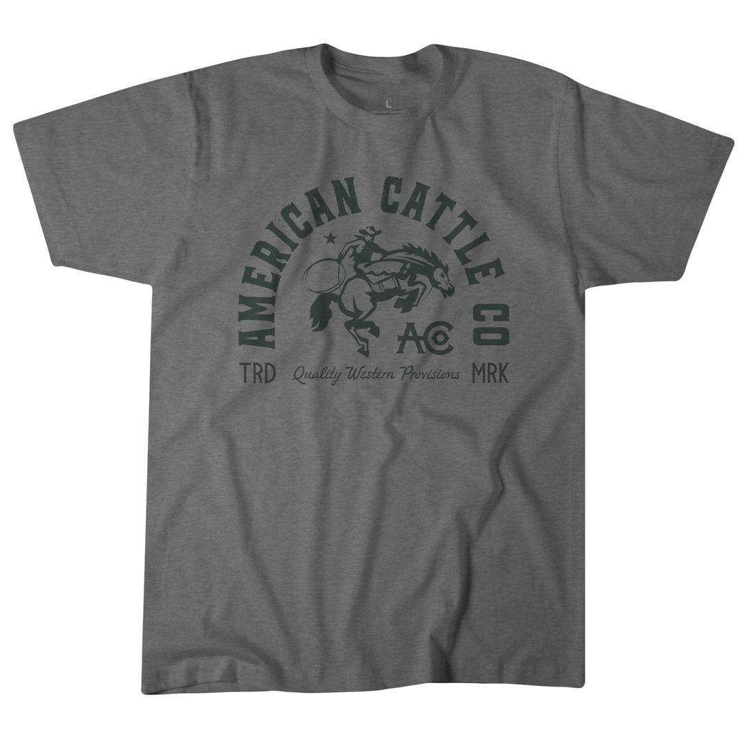 The Ride 'Em Cowboy Tee by American Cattle Co features a bold "American Cattle Co," "TRD," "Quality Western Provisions," and "MRK" print with a bucking horse and rider—ideal for fans of classic American cowboy style.