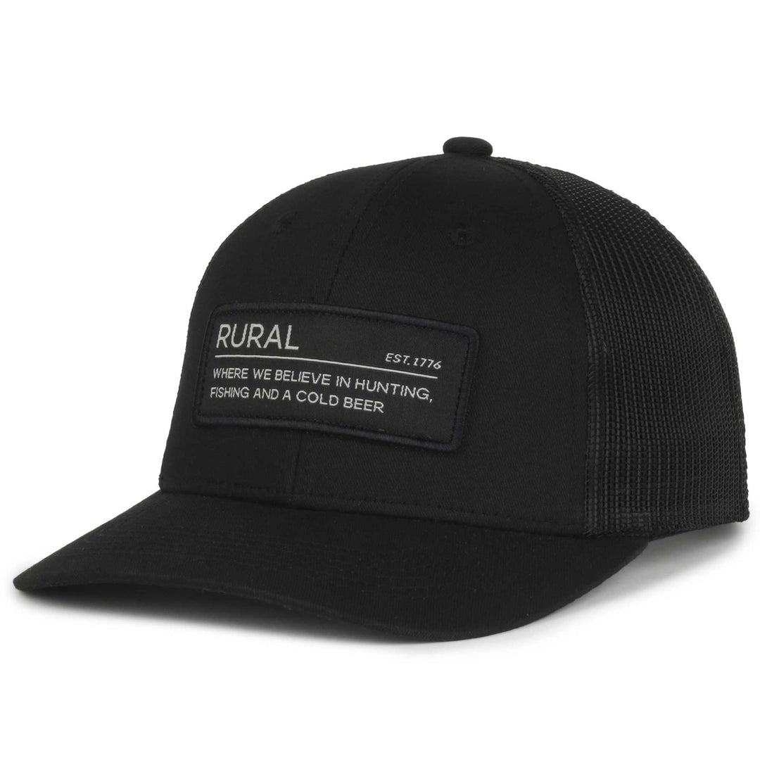 The Rural Def Hat by American Cattle Co is a black snapback with a mesh back and front patch saying "RURAL, EST. 1776." It celebrates rural life, featuring the motto "WHERE WE BELIEVE IN HUNTING, FISHING AND A COLD BEER" in white text, ideal for outdoor enthusiasts.