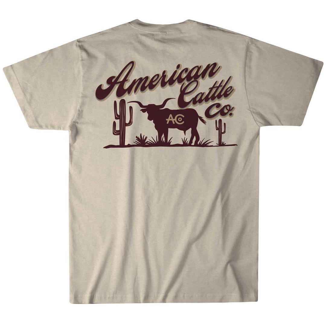The cream Shadowhorn Tee from American Cattle Co features a bold longhorn silhouette between two cacti, with "American Cattle Co." and "AC" in dark brown, encapsulating the spirit of the cattleman's code.