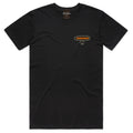 The Stephenville Tee by American Cattle Co is a black short-sleeve shirt featuring a small oval orange and yellow Bucktown diamond logo on the left chest, shown laid flat on a white background.