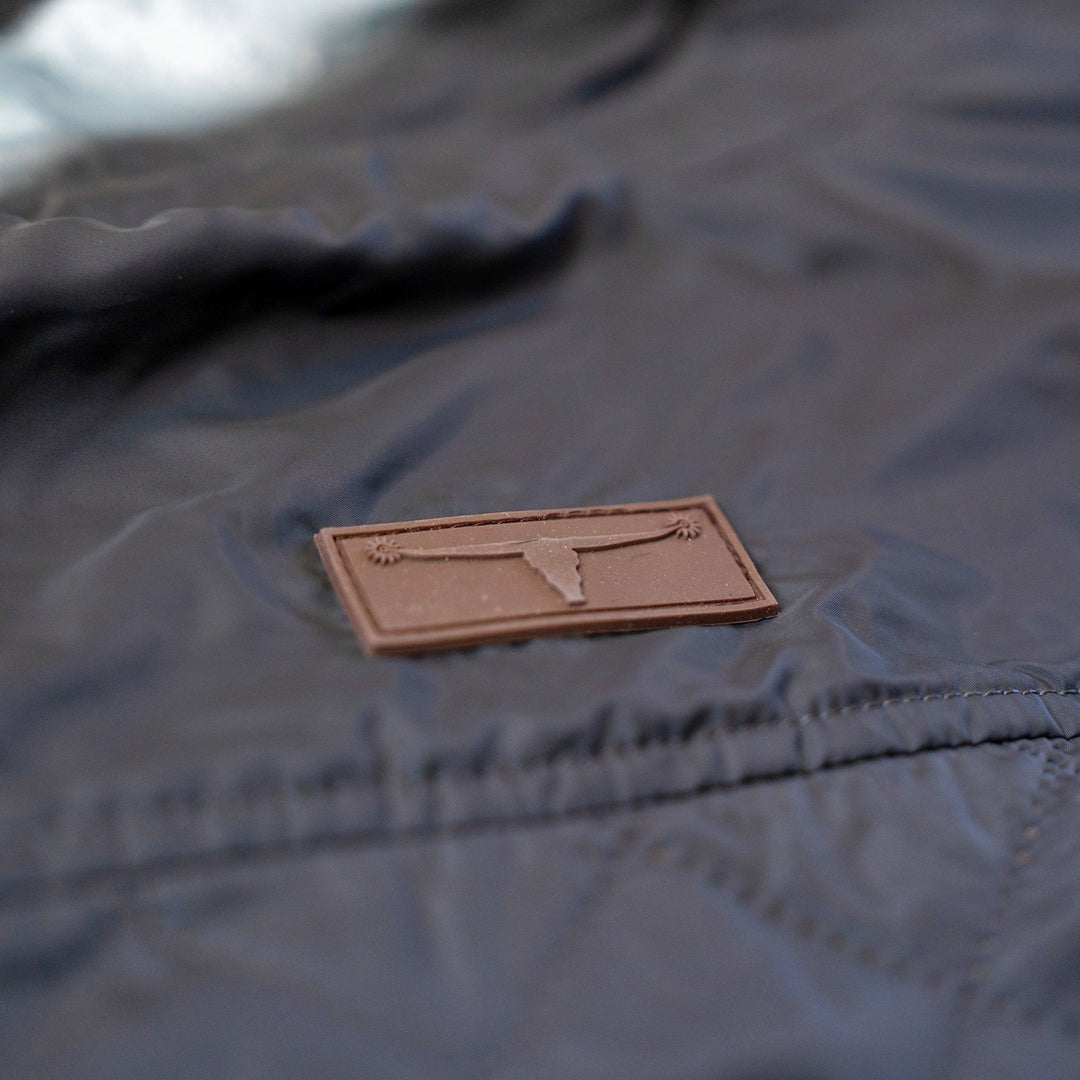 Leather longhorn logo patch on the quilted shell of the Sunday Jacket in Thundercloud.