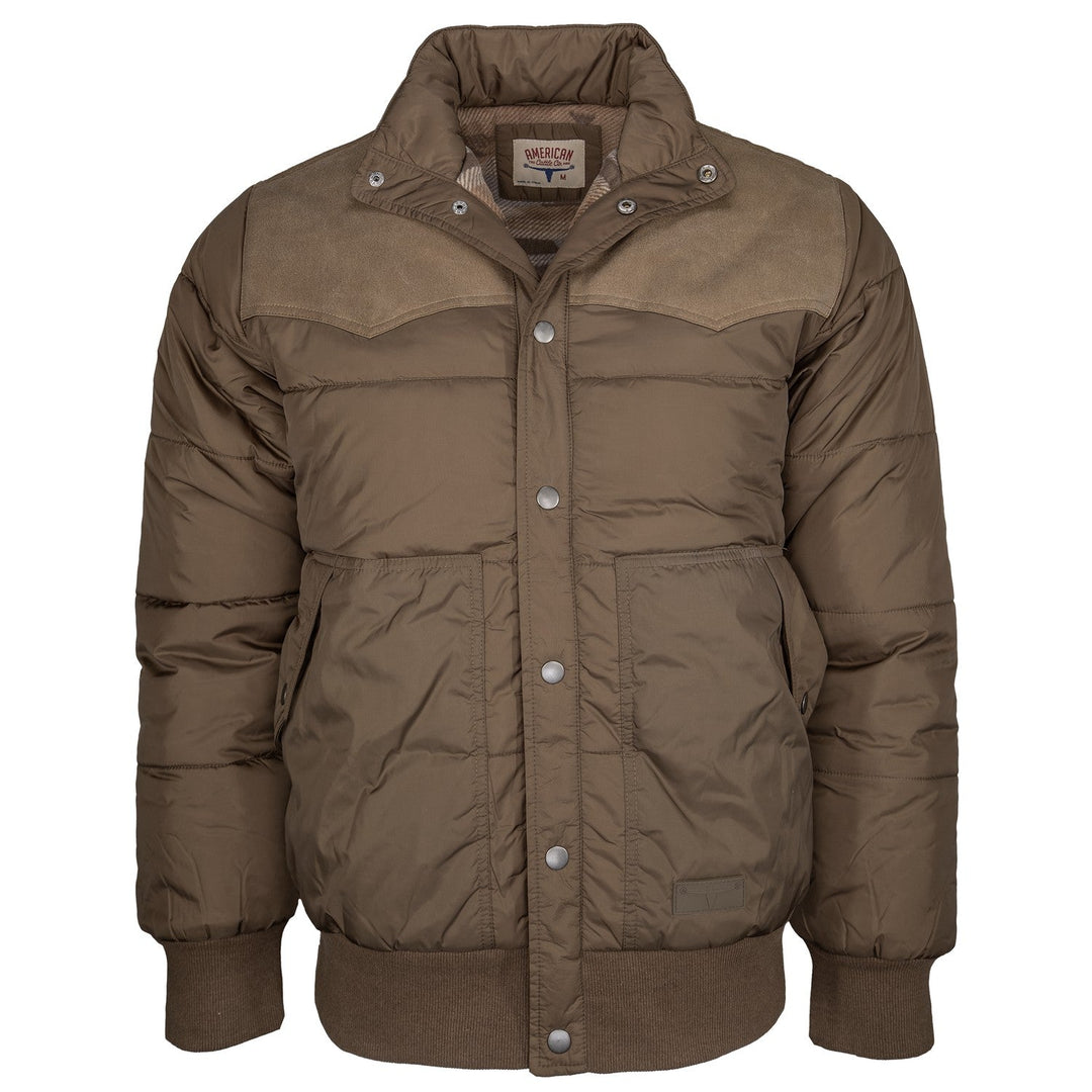 Introducing The Cold Snap Puffer—a brown, padded winter jacket designed with snap buttons, ribbed cuffs and hem, two spacious front pockets, and a high collar. This western-inspired puffer stands out with its canvas-like yoke detail across the shoulders and chest for added style and durability.