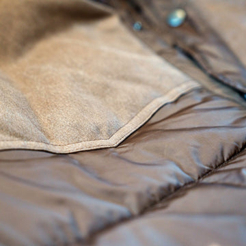 Close-up of the canvas-like western yoke over the quilted puffer body of The Cold Snap Puffer in Cocoa.