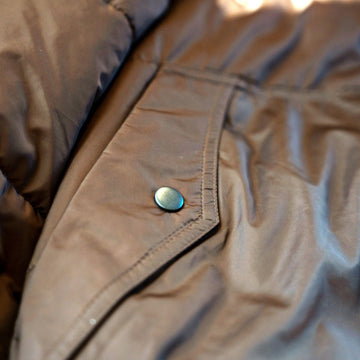 Snap-close front pocket on The Cold Snap Puffer in Cocoa.