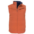 The Switchback Reversible Puffer by Rural Cloth is an orange quilted sleeveless vest featuring a front zipper, high collar, and a zippered chest pocket. Its versatile design includes a contrasting dark navy inner lining, providing a modern twist on the classic western vest style.