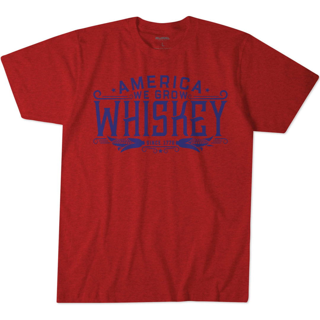 The America We Grow Whiskey Tee-Heather Red by American Cattle Co features blue text, “America We Grow Whiskey Since 1795,” across the chest—a tribute to tradition and corn farmers, proudly made in the USA.