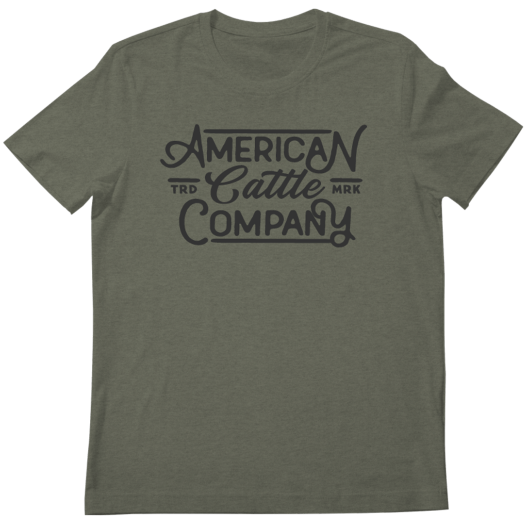 The Billboard Script Tee by American Cattle Co is an olive green shirt featuring "American Cattle Company" in bold script and "TRD MRK" by "Cattle," ideal for American ranching fans who appreciate classic style.