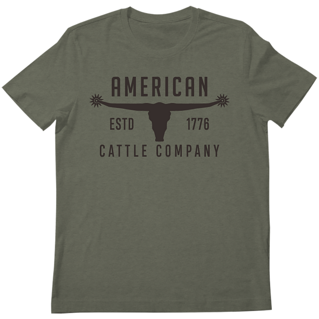 The Bull Spurs Tee-Heather Sage by American Cattle Co is a heather sage Western t-shirt featuring “AMERICAN CATTLE COMPANY ESTD 1776” and a longhorn skull graphic with star-tipped horns—delivering a classic wild west look.