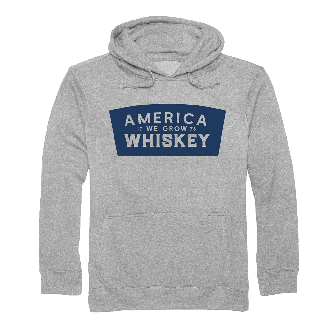 The Keystone Pullover by Rural Cloth is a gray sweatshirt with a blue rectangular chest graphic that reads "AMERICA WE GROW WHISKEY," featuring stylized lines and the numbers "17" and "76"—ideal for American whiskey fans.