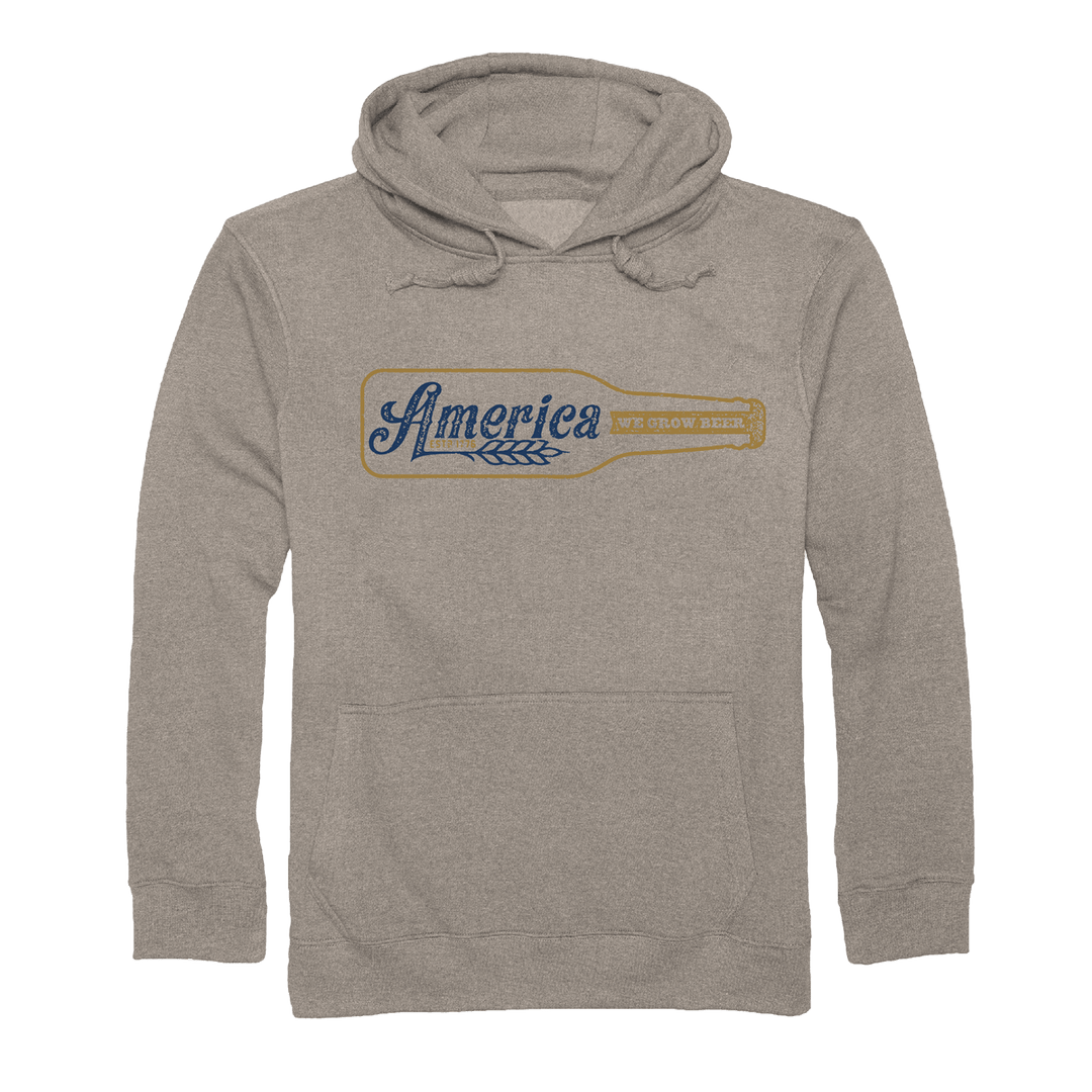 The Rural Cloth Longneck Pullover is a light brown hoodie with a tap handle graphic, “America” in blue script, “We Grow Beer” in yellow, and wheat accents—a must-have for true American brewing fans.
