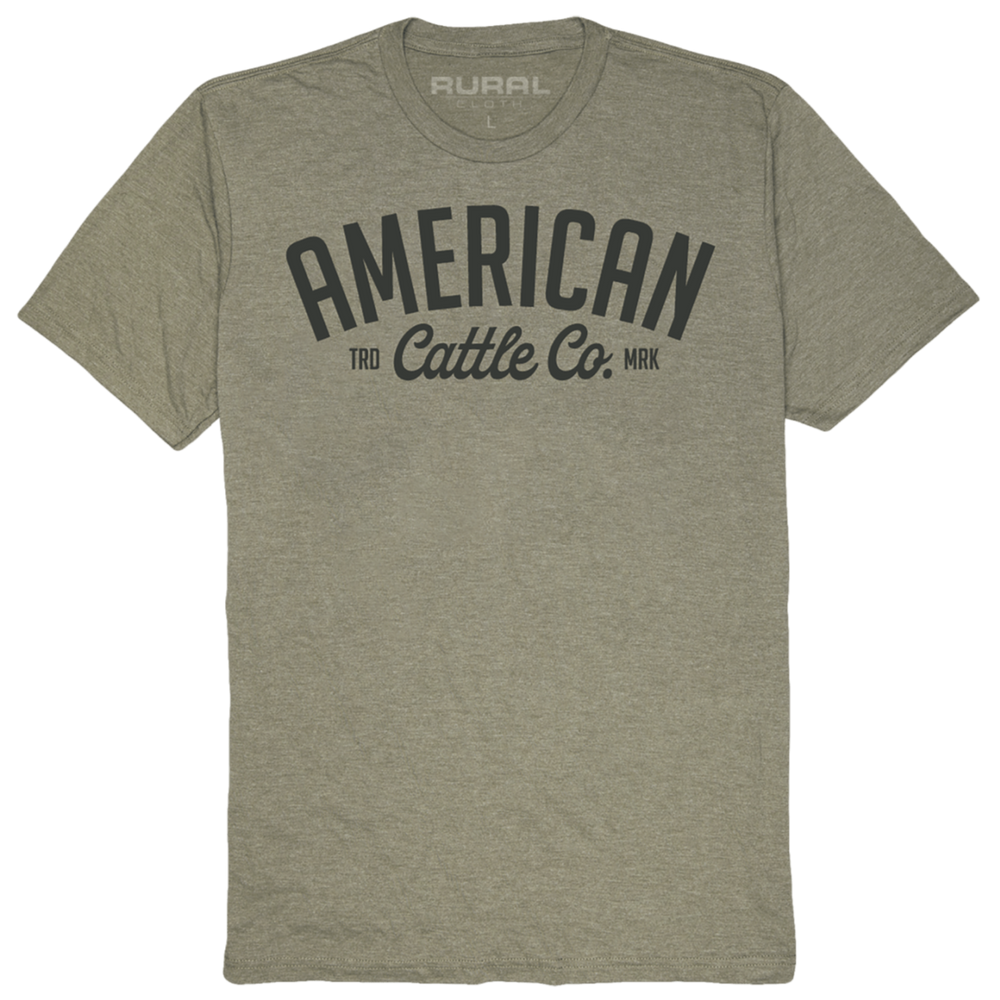 The Trademark Tee by Rural Cloth is a heather gray, short-sleeve shirt featuring "AMERICAN Cattle Co." in bold black with "TRD MRK" below. Made from premium weight fabric, it has "RURAL" subtly printed inside the collar.