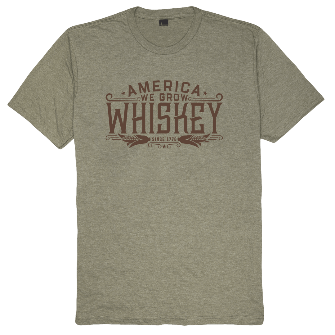 The We Grow Whiskey Tee-Military Green Frost by American Cattle Co is made from premium-weight fabric, featuring a modern athletic fit and bold front text—perfect for corn farmers.