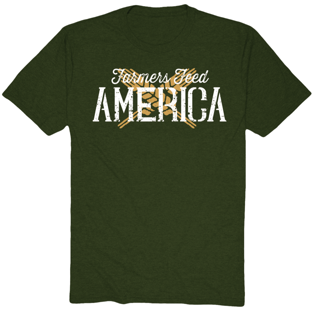 Show your American pride with the Wheat X Tee-Olive by American Cattle Co, featuring white distressed "Farmers Feed America" text and two crossed yellow pitchforks on a dark green shirt.